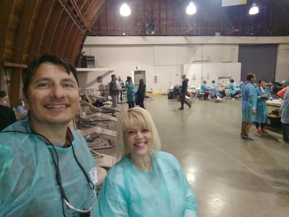 Doctor Paskalev smiling with dental team member at community event