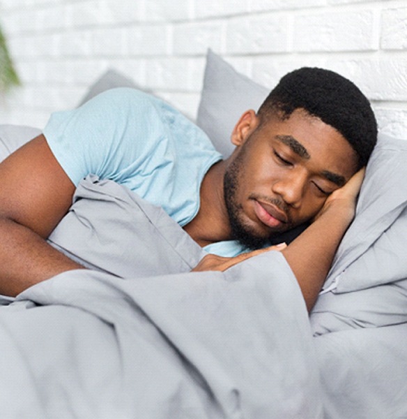 Man sleeping peacefully after using medical insurance for sleep apnea treatment