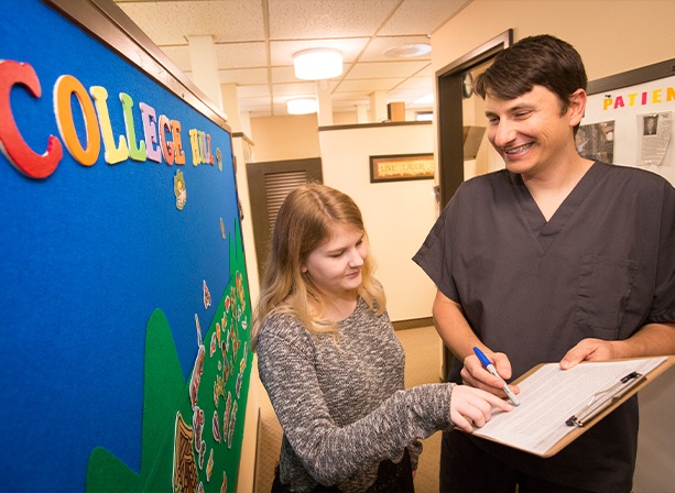 Doctor Paskalev showing a clipboard to a patient in Eugene sleep apnea dental office