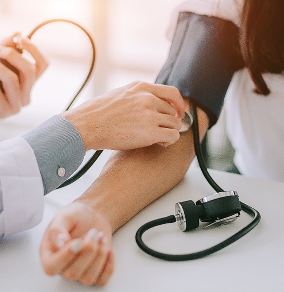 doctor taking woman’s blood pressure 