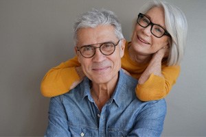 Older man and woman wearing glasses and smiling