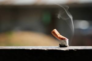 Cigarette extinguished on a wooden railing