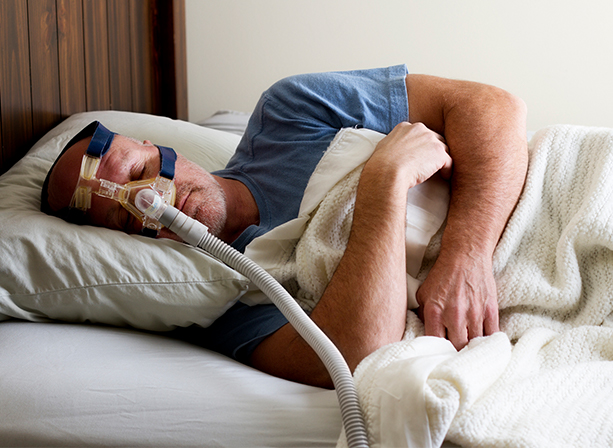 Man with CPAP and oral appliance combined sleep apnea therapy sleeping soundly