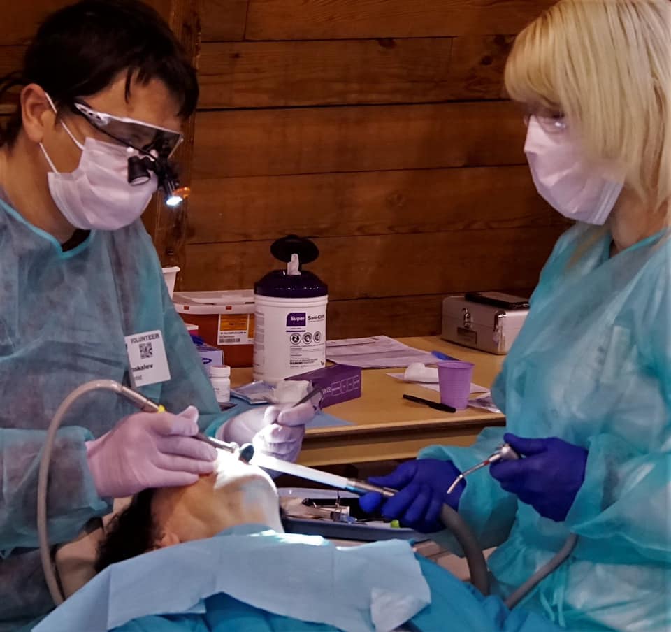 Doctor Paskalev and dental team member treating patient at community event