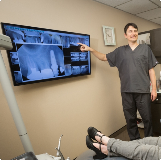 Doctor Paskalev pointing to x rays of a patient's mouth