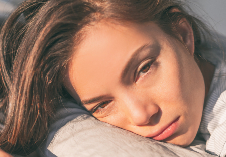 Tired woman resting her head on pillow