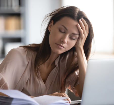 Woman struggling to focus on her laptop computer