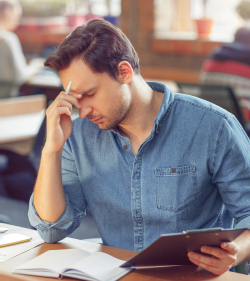 Frustrated man looking at forms struggling to remember details