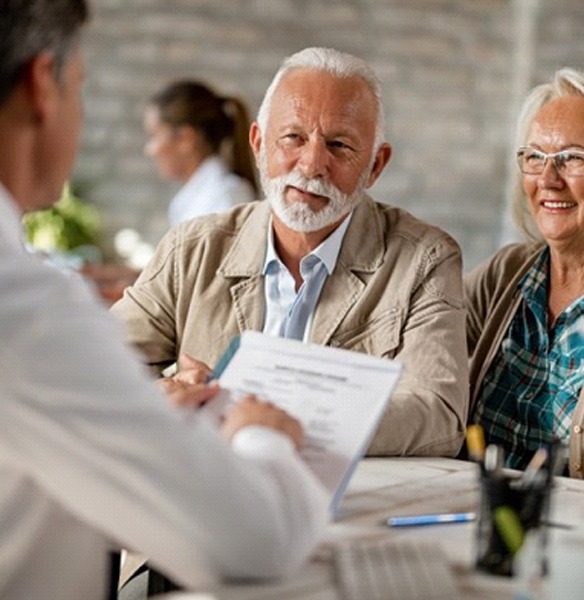 Senior couple working through insurance paperwork with doctor