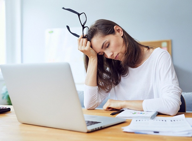 Woman falling asleep at desk due to obstructive sleep apnea in Eugene