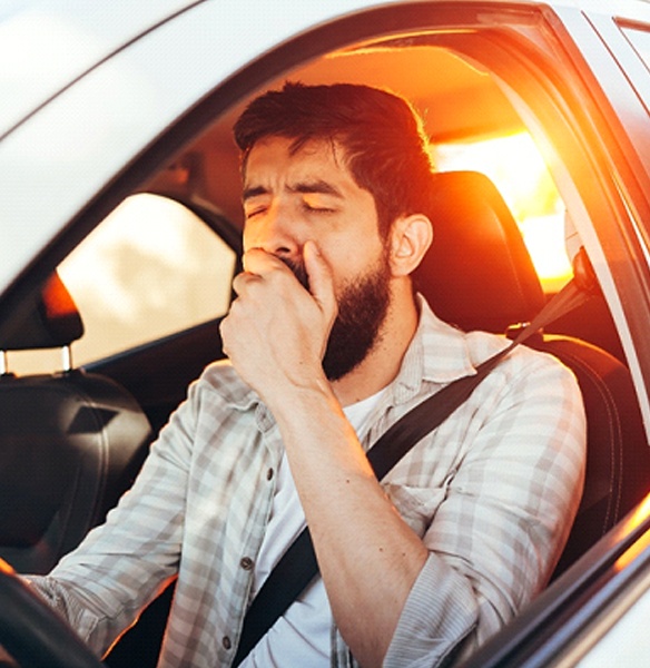 Tired man with sleep apnea yawning while driving