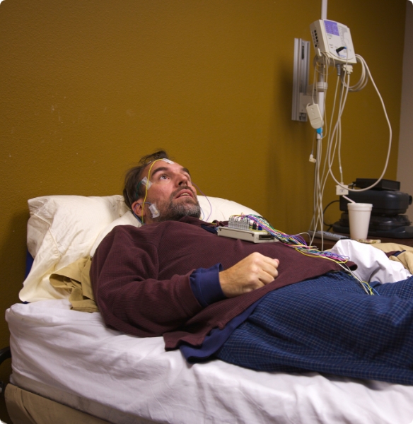 Man with electrodes attached to his body during sleep apnea treatment