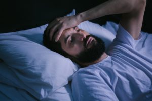 Exhausted man struggling with sleep apnea in Eugene