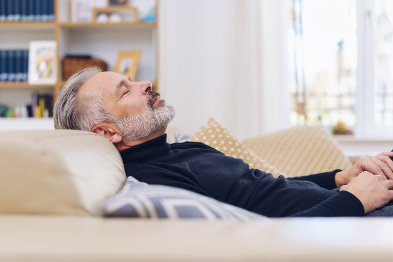 Man with sleep apnea napping on his couch