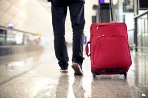 Person traveling with sleep apnea, dragging suitcase through airport