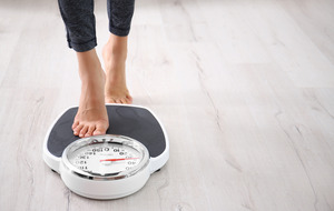 Woman stepping onto a scale to check weight